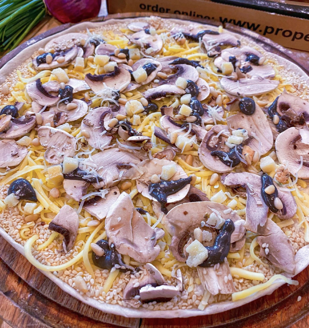 raw cheese pizza with mushroom and black truffle toppings